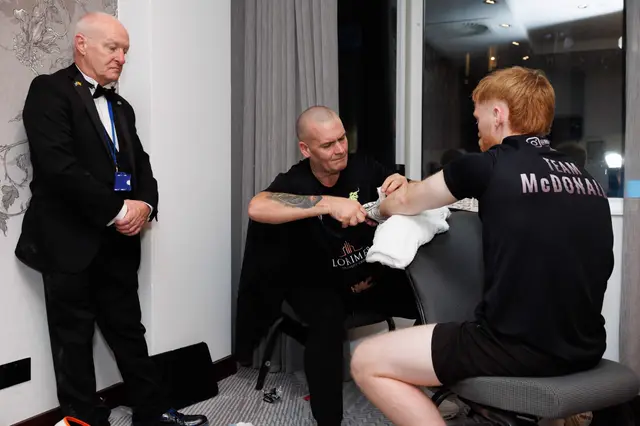 Matthew in a Team McDonald T-shirt having his hands wrapped