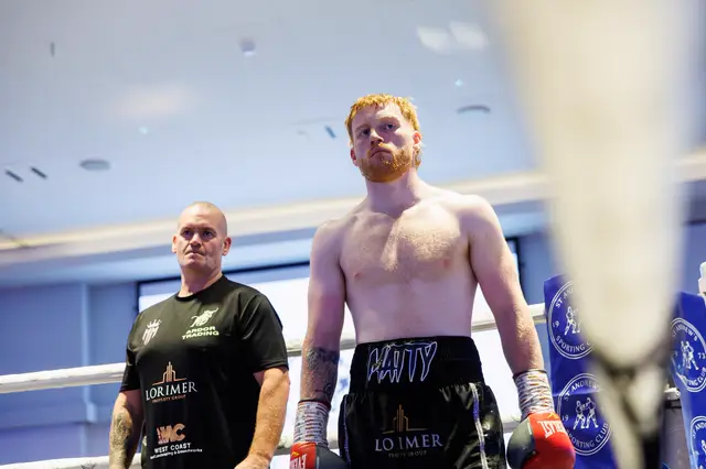 Matthew standing in the ring with his cornerman behind him