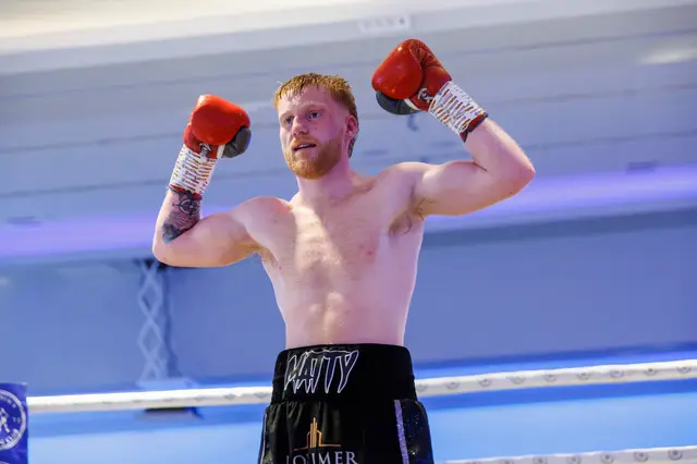 Matthew raising both gloves in the ring