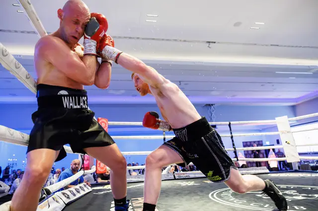 Matthew attacking Steven Wallace, who covers up on the ropes
