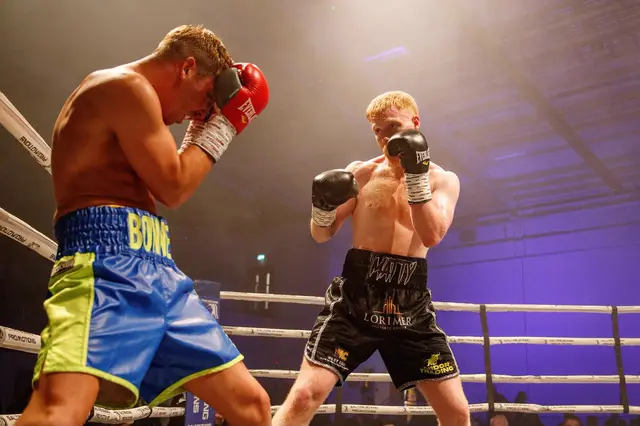 Matthew squaring up to an opponent in blue and green shorts