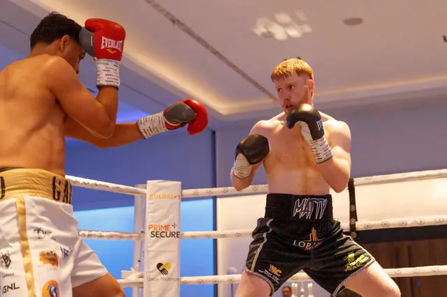 Matthew, hands up, facing an opponent in white and gold shorts