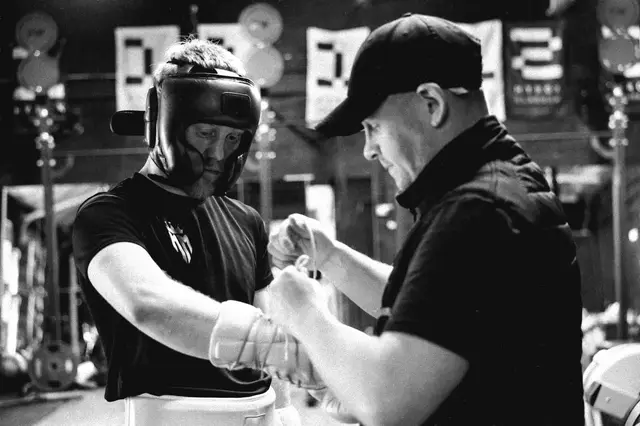 Matthew in a headguard while his gloves are tied